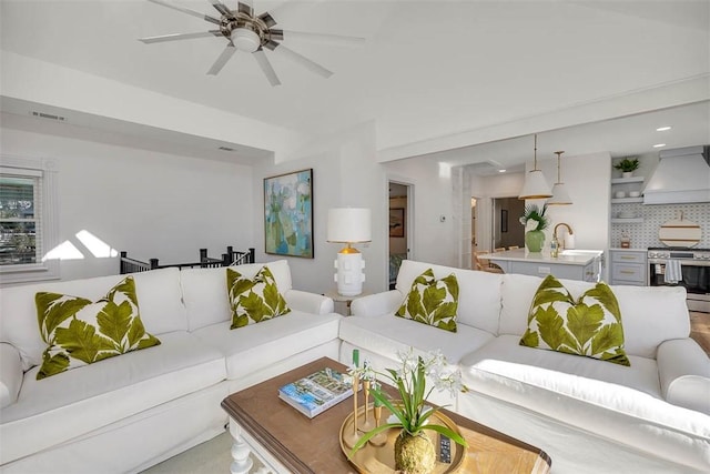 living room with ceiling fan and sink