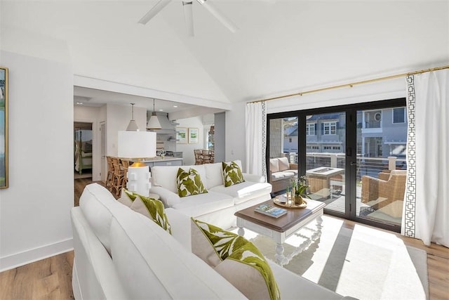 living room featuring ceiling fan, light wood-type flooring, and high vaulted ceiling