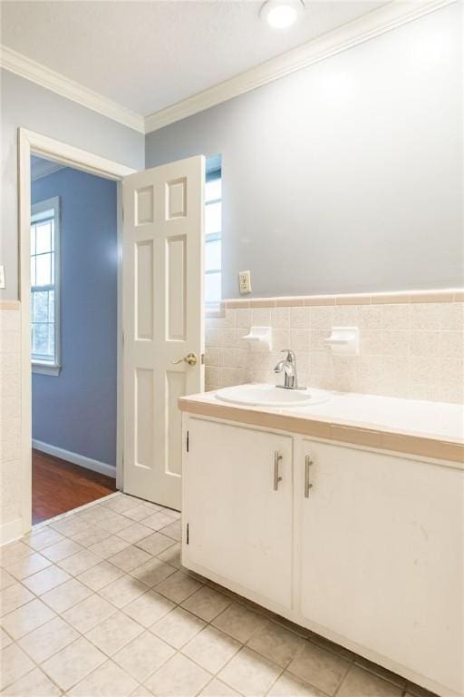 1878 Blalock Ave, Waycross, GA 31503 - bathroom featuring ornamental molding, tile patterned flooring, vanity, tile walls, and a wainscoted wall