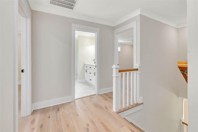 134 Newfield St, Saint Simons Island, GA 31522 - hall with an upstairs landing, light wood-type flooring, and ornamental molding