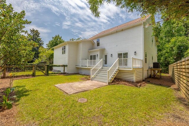 134 Newfield St, Saint Simons Island, GA 31522 - rear view of house with a fenced backyard, a wooden deck, a patio area, and stairs