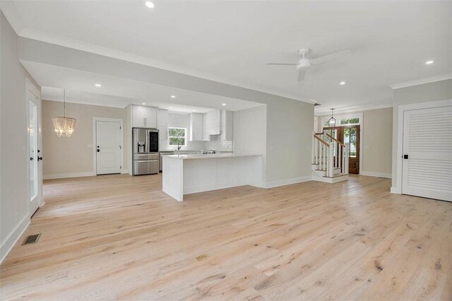 134 Newfield St, Saint Simons Island, GA 31522 - unfurnished living room with ornamental molding, light wood-style flooring, a chandelier, recessed lighting, and stairway
