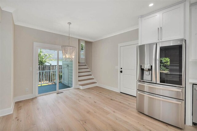 134 Newfield St, Saint Simons Island, GA 31522 - kitchen featuring stainless steel fridge, a chandelier, crown molding, light wood finished floors, and white cabinetry