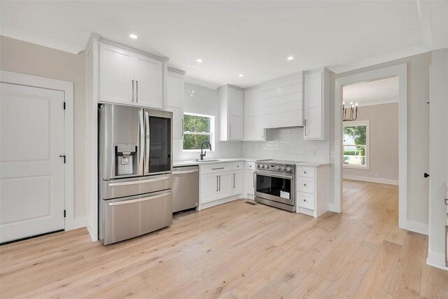 134 Newfield St, Saint Simons Island, GA 31522 - kitchen featuring stainless steel appliances, healthy amount of natural light, light countertops, white cabinets, and ornamental molding