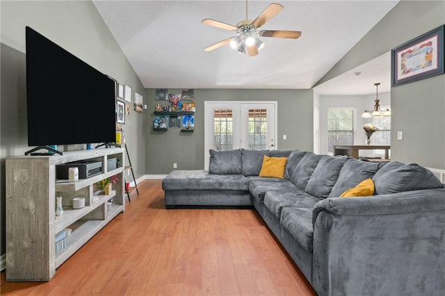 living room featuring a ceiling fan, baseboards, lofted ceiling, and wood finished floors