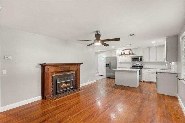 2388 Waycross Hwy, Jesup, GA 31545 - kitchen with appliances with stainless steel finishes, a ceiling fan, a kitchen island, dark wood-style floors, and recessed lighting