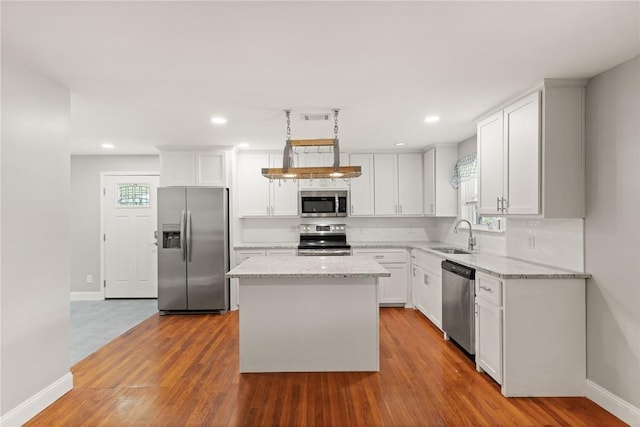 2388 Waycross Hwy, Jesup, GA 31545 - kitchen with stainless steel appliances, light stone counters, white cabinetry, wood finished floors, and recessed lighting