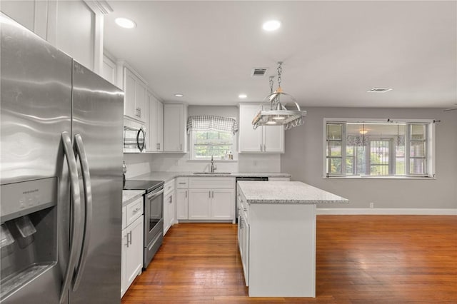 2388 Waycross Hwy, Jesup, GA 31545 - kitchen with appliances with stainless steel finishes, a kitchen island, recessed lighting, dark wood-style floors, and white cabinets