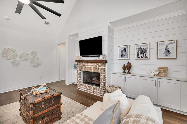 506 Conservation Dr, Saint Simons Island, GA 31522 - living area featuring a ceiling fan, wood finished floors, high vaulted ceiling, a brick fireplace, and baseboards