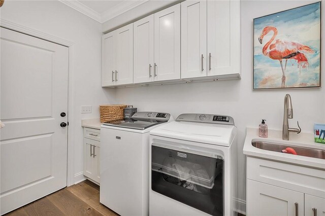 506 Conservation Dr, Saint Simons Island, GA 31522 - washroom featuring ornamental molding, washer and clothes dryer, cabinet space, and dark wood-style flooring