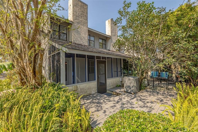 back of property with a sunroom and a patio area