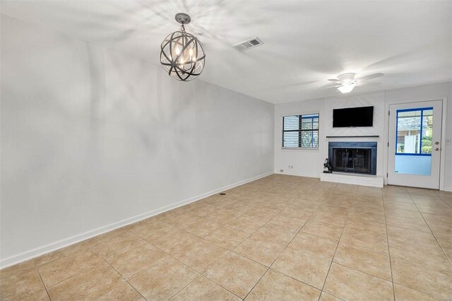 unfurnished living room featuring ceiling fan with notable chandelier and light tile patterned floors