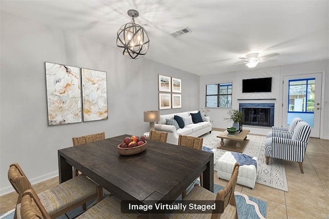 dining area featuring ceiling fan with notable chandelier and light tile patterned flooring