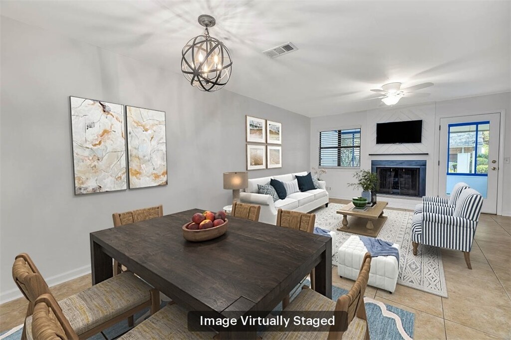 dining area featuring ceiling fan with notable chandelier and light tile patterned flooring