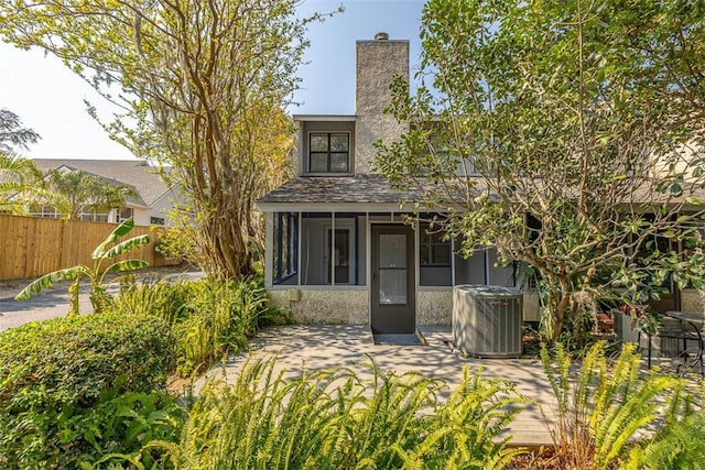 rear view of property with a patio, central AC unit, and a sunroom