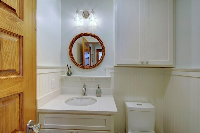 605 Ocean Blvd, Saint Simons Island, GA 31522 - half bathroom with vanity, a wainscoted wall, and a decorative wall