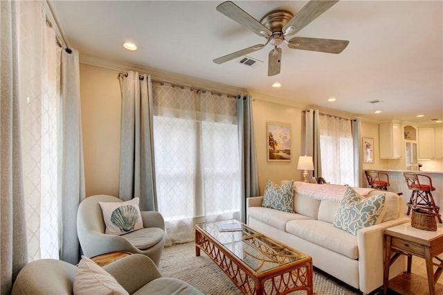 living room with ceiling fan and crown molding