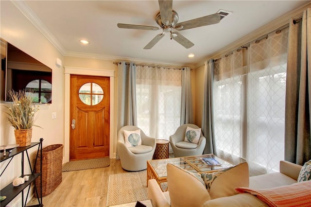 sitting room featuring crown molding, a healthy amount of sunlight, and light wood-type flooring