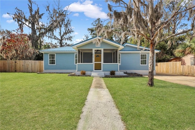 view of front of home featuring metal roof, fence, and a front yard