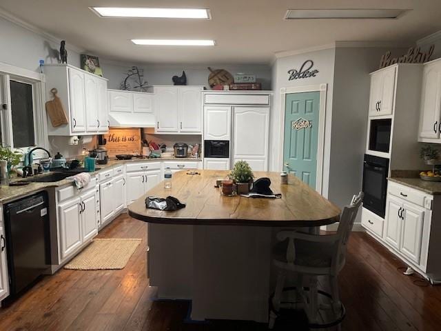 2204 Gibbs St, Waycross, GA 31503 - kitchen featuring black appliances, under cabinet range hood, white cabinetry, a sink, and crown molding