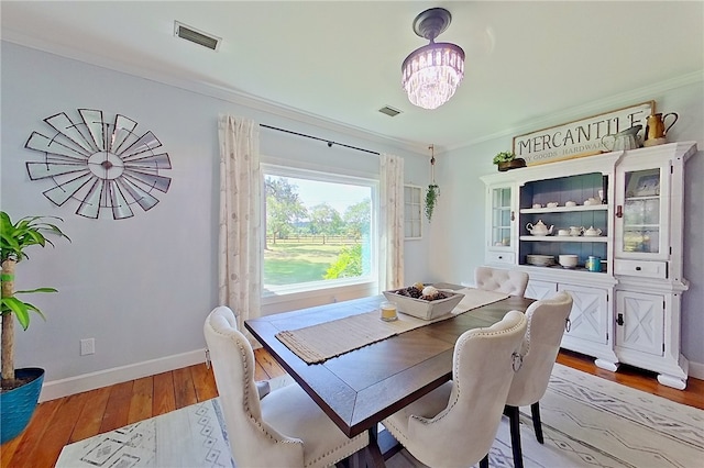 2204 Gibbs St, Waycross, GA 31503 - dining space with a chandelier, ornamental molding, and light wood-style flooring