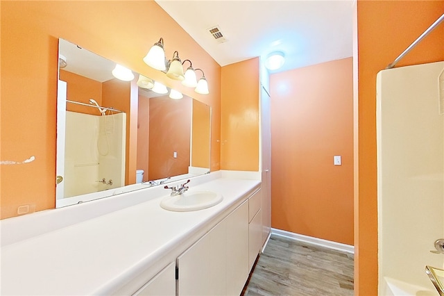 2204 Gibbs St, Waycross, GA 31503 - bathroom featuring wood finished floors, vanity, and shower / tub combination