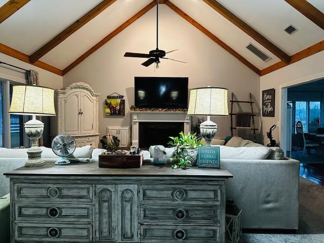 2204 Gibbs St, Waycross, GA 31503 - living room featuring high vaulted ceiling, beam ceiling, a ceiling fan, and a fireplace