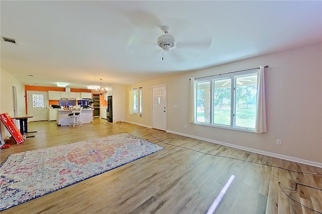 2204 Gibbs St, Waycross, GA 31503 - unfurnished living room featuring a chandelier, a ceiling fan, and light wood-style floors