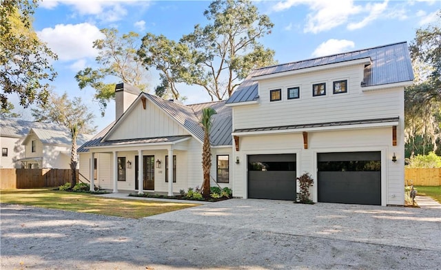 modern farmhouse style home with covered porch, a front yard, and a garage