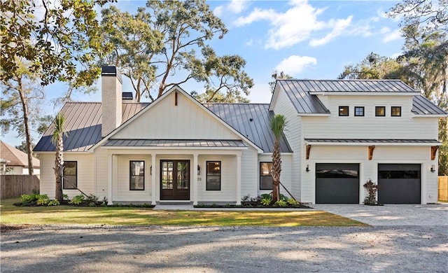 modern farmhouse style home with a front lawn, a garage, and french doors