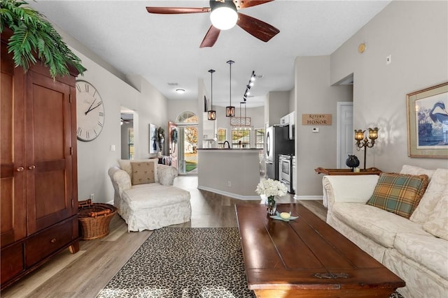 living room featuring ceiling fan and light hardwood / wood-style floors