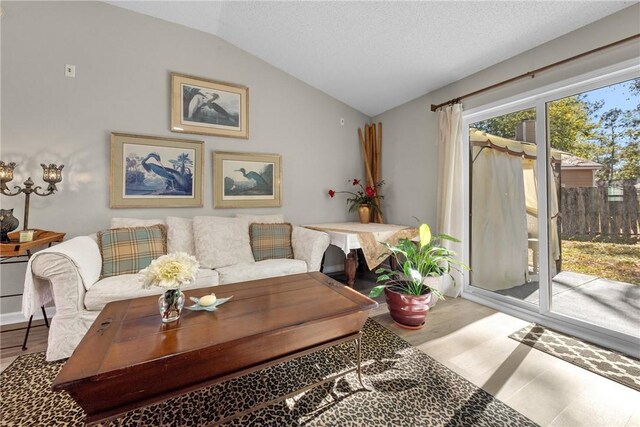 bedroom with a textured ceiling, light hardwood / wood-style floors, ceiling fan, and lofted ceiling