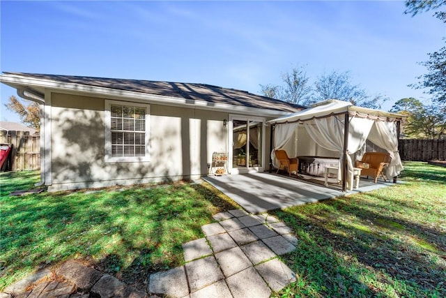 rear view of property featuring a lawn and a patio area