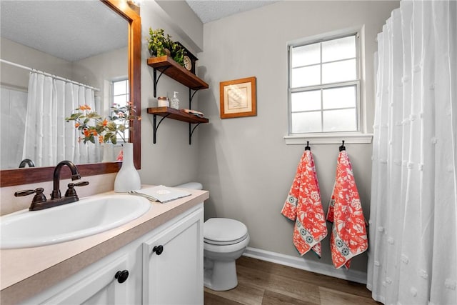 bathroom featuring vanity, wood-type flooring, a textured ceiling, and toilet