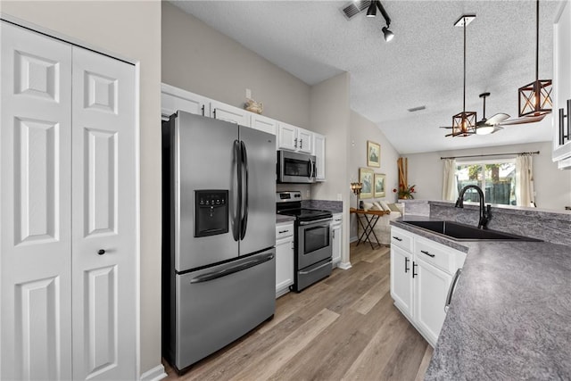 kitchen with white cabinetry, sink, lofted ceiling, and stainless steel appliances