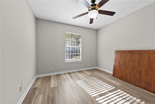 spare room featuring ceiling fan, light hardwood / wood-style floors, and a textured ceiling