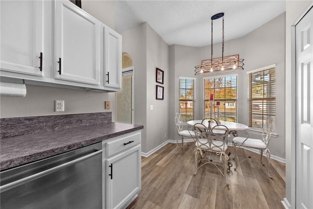 kitchen featuring white cabinets, dishwasher, light hardwood / wood-style floors, and decorative light fixtures