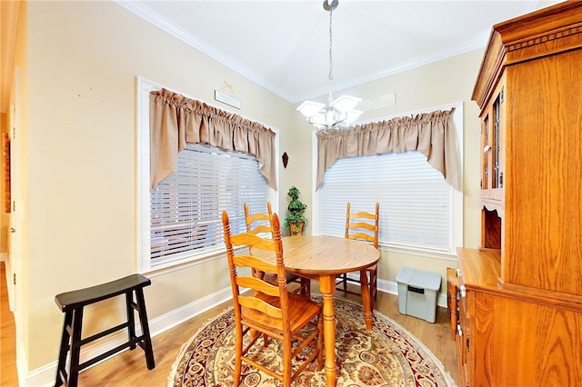 dining room with light hardwood / wood-style floors, crown molding, and a chandelier