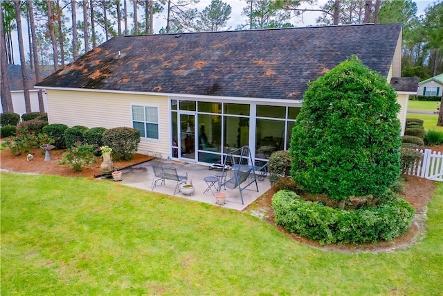 back of property with a yard and a patio