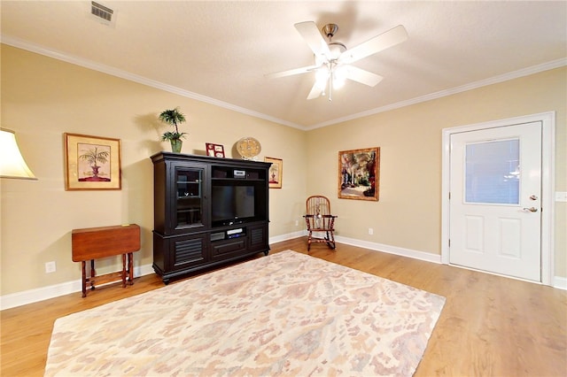 sitting room with ceiling fan, wood-type flooring, and crown molding