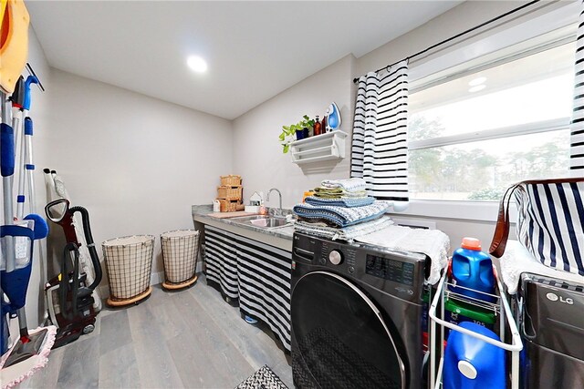 washroom with a sink, washer / dryer, laundry area, and wood finished floors
