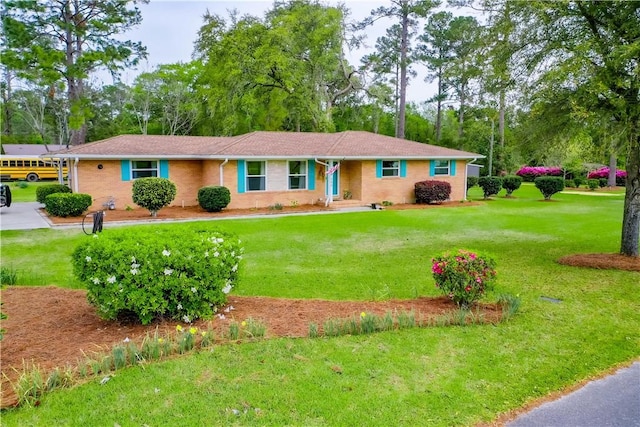 ranch-style house featuring brick siding and a front lawn