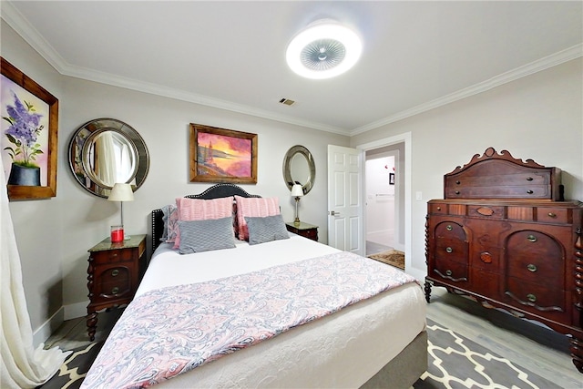bedroom featuring baseboards, visible vents, light wood-style floors, and ornamental molding