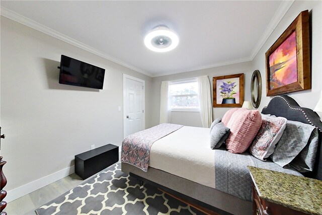 bedroom featuring crown molding, baseboards, and wood finished floors