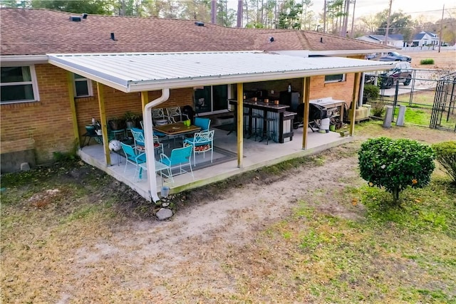 back of house featuring fence, a patio, and brick siding