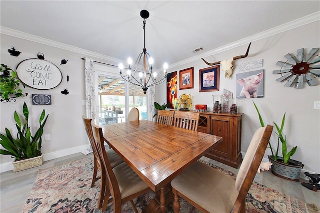 dining area featuring crown molding, visible vents, and a notable chandelier