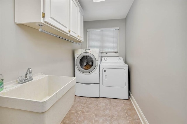 washroom with cabinets, independent washer and dryer, light tile patterned floors, and sink