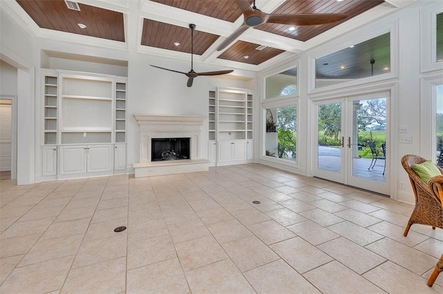 unfurnished living room featuring french doors, built in shelves, a towering ceiling, light tile patterned floors, and wood ceiling