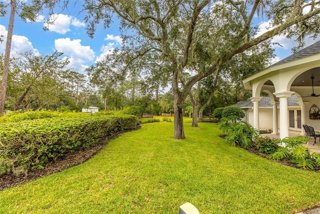 view of yard featuring ceiling fan and french doors