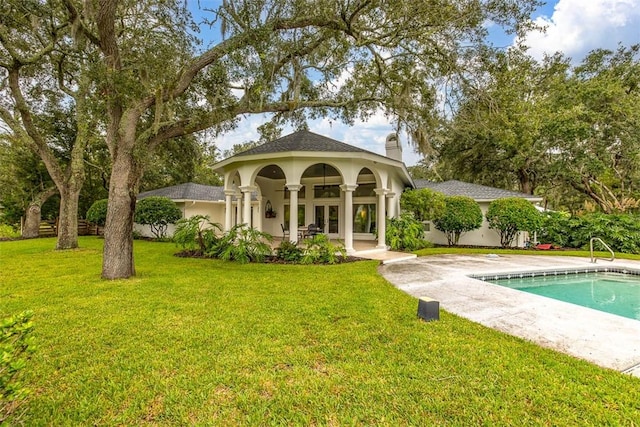 rear view of house with a lawn and a patio area